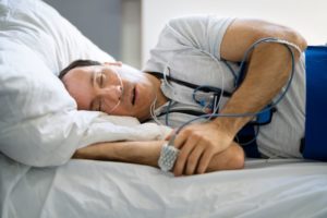 Man wearing monitoring equipment during sleep test